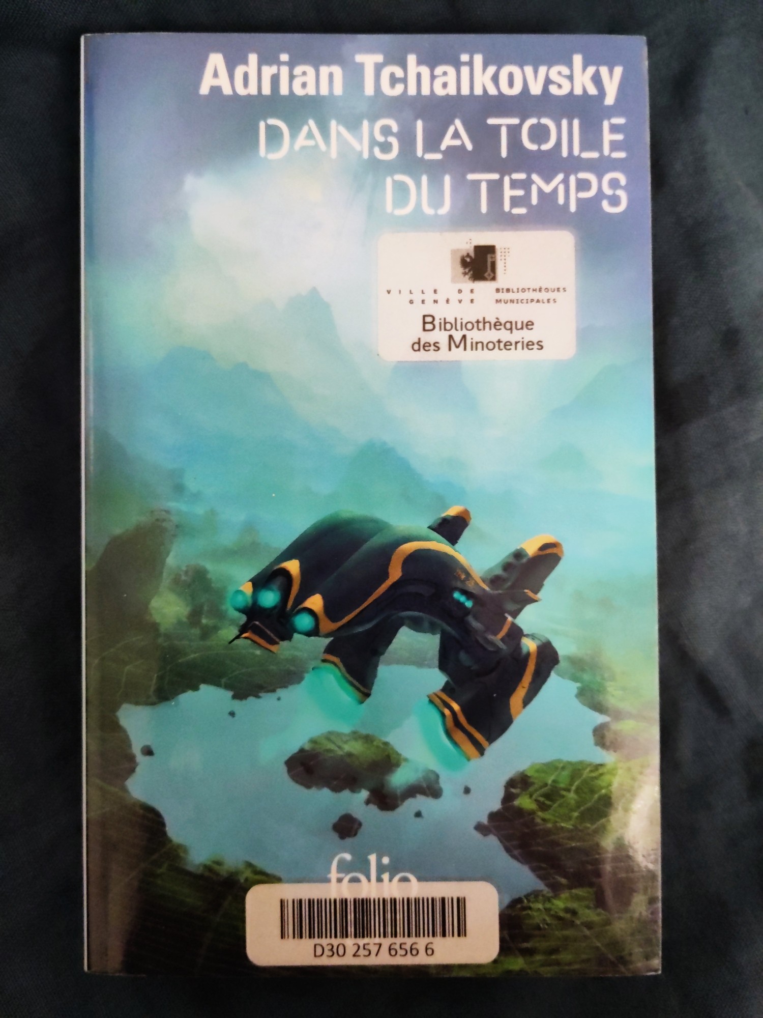 photo de la couverture du livre "Dans la toile du temps" d'Adrian Tchaïkovski (folio).
un vaisseau jaune et noir en vol avec en arrière plan une planète verdoyante.