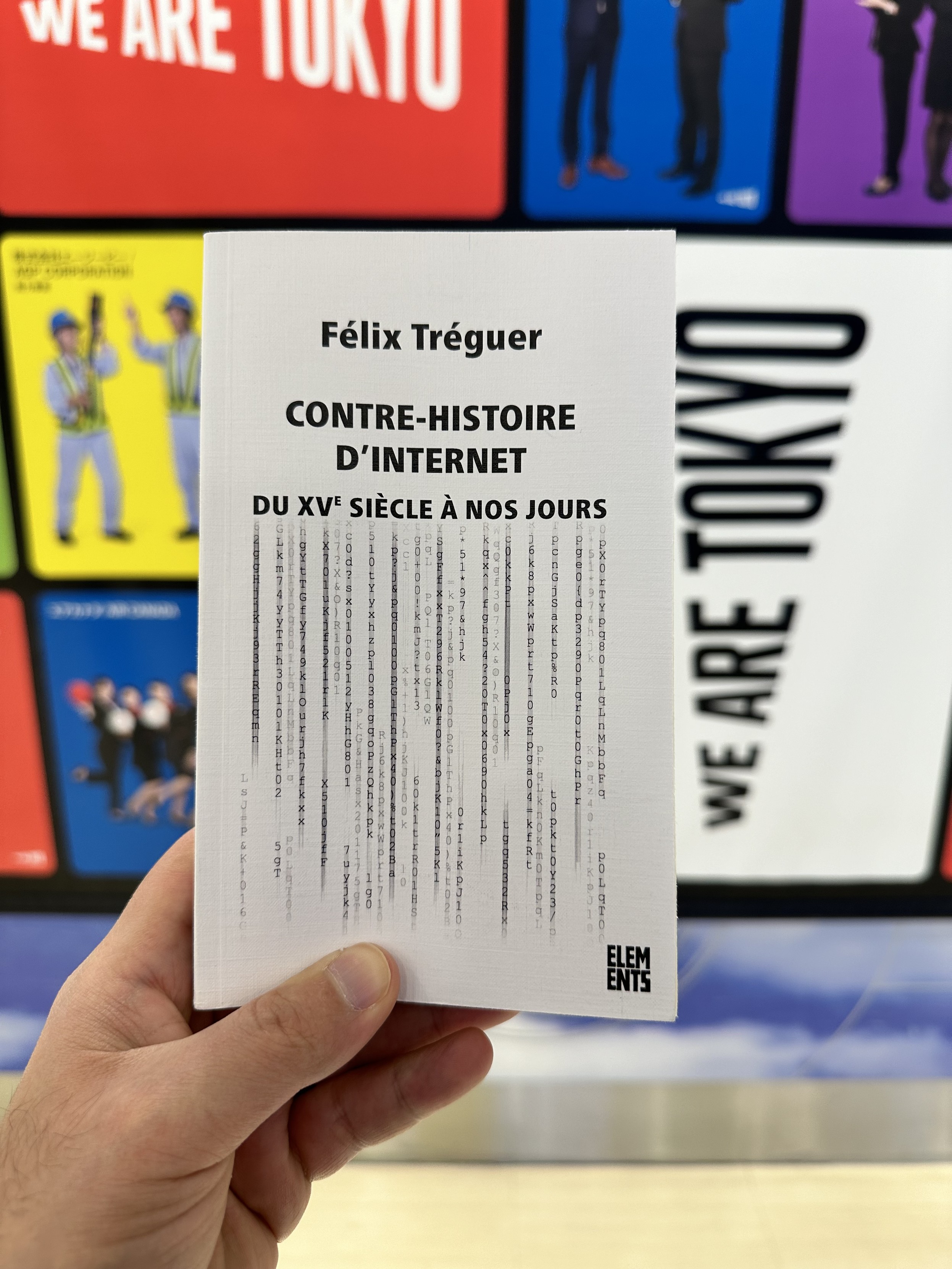 Couverture du livre « Contre histoire d’Internet » de Félix Tréguer.
En arrière plan, une affiche colorée « We are Tokyo » présentant différentes entreprises et employés de l’aéroport 